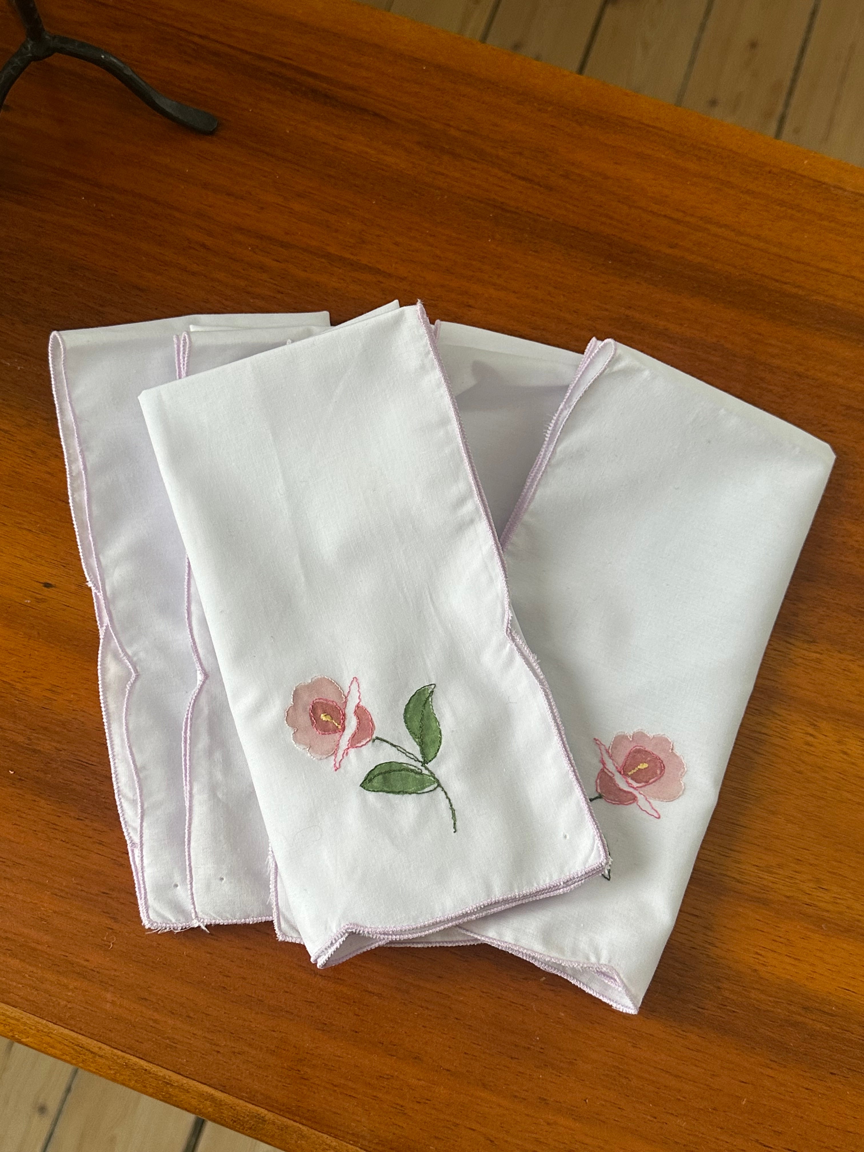 Tygservetter med blomma och broderad kant